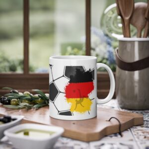 Germany Football Mug featuring a football as a background design with the map of Germany in the the German national colours. It has a player executing a bicycle kick.